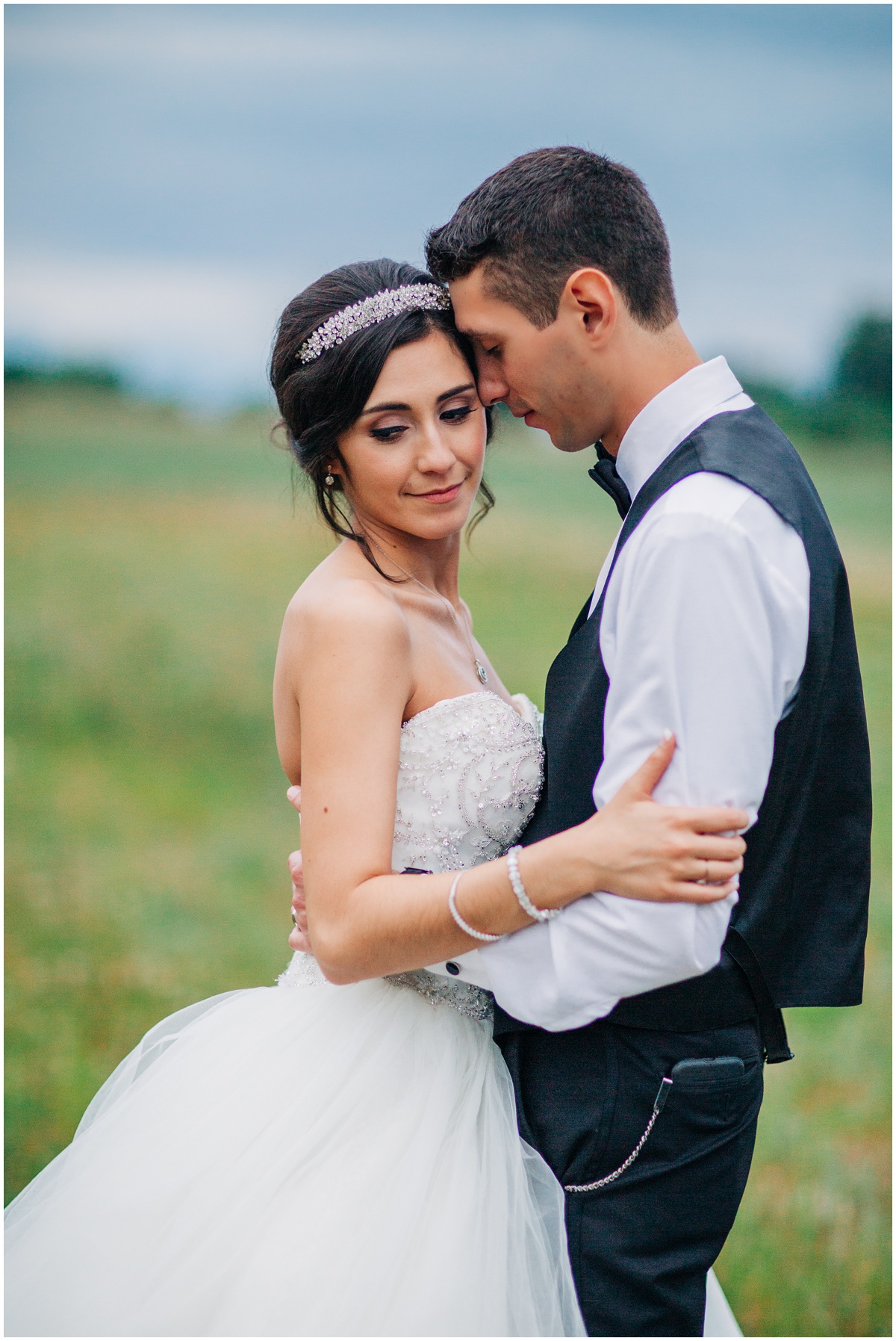 bride and groom with heads close in field | Hidden Meadows Wedding Snohomish Washington