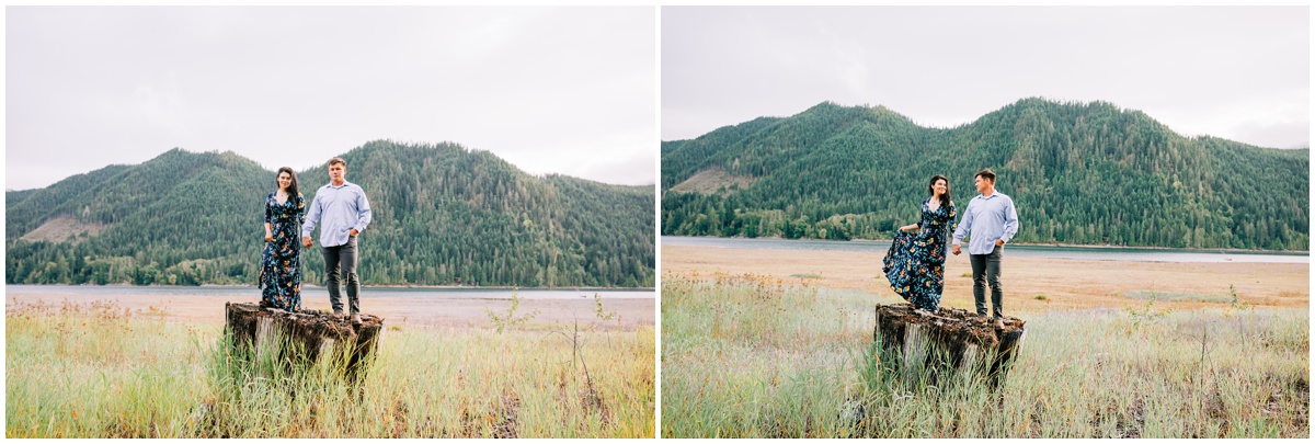 man and woman standing on tree stump