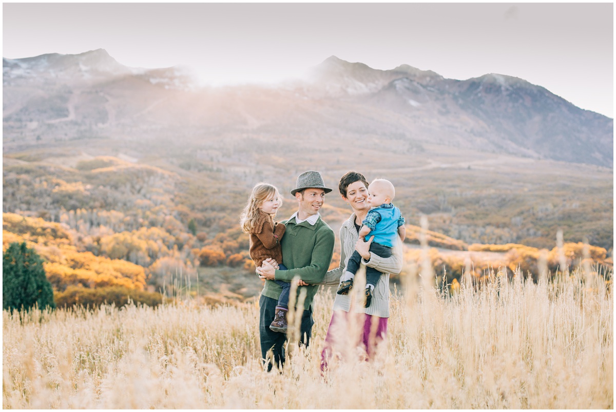 family standing in field with sunset