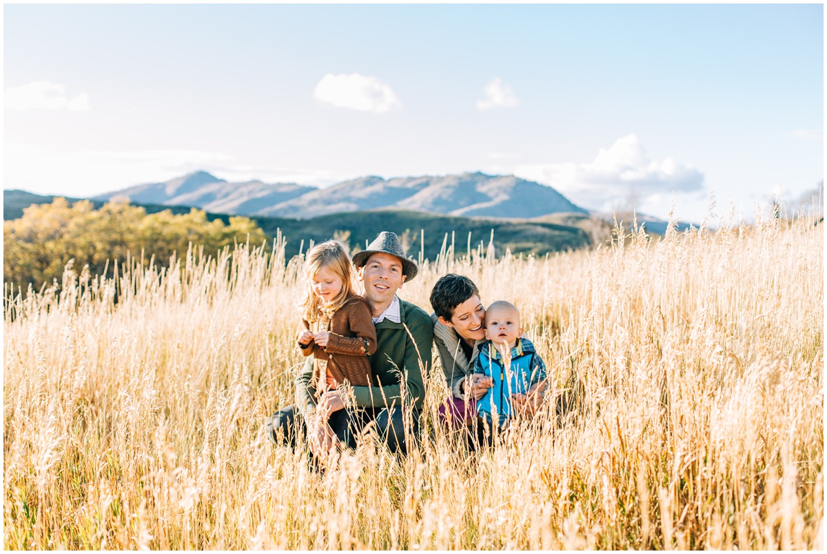 mom and dad with kids crouching in tall grass