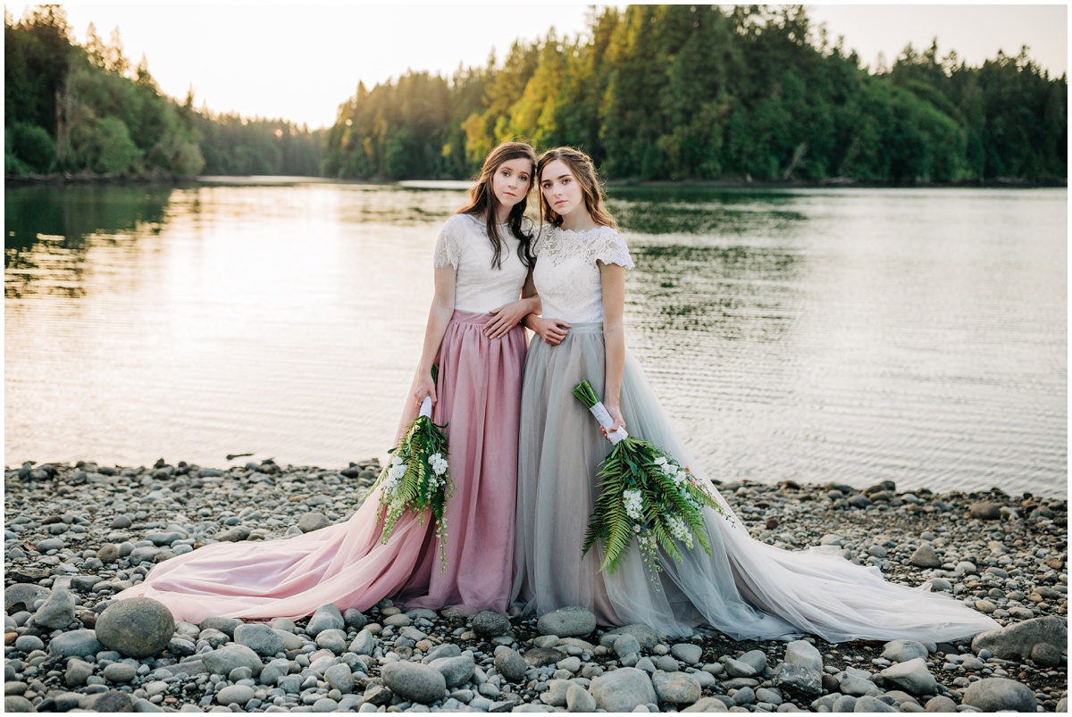 two brides standing on rocky beach