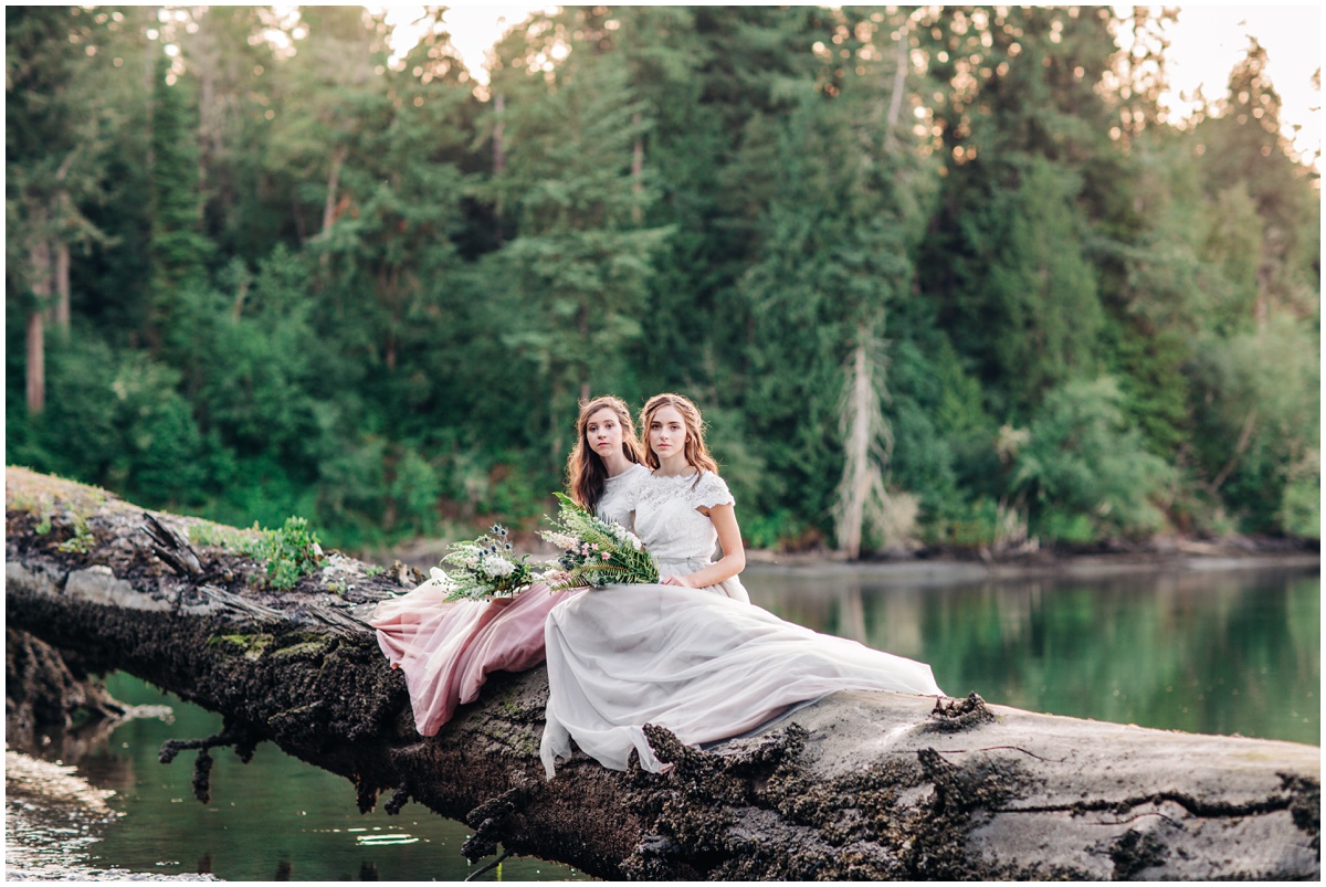 two brides face camera with forest