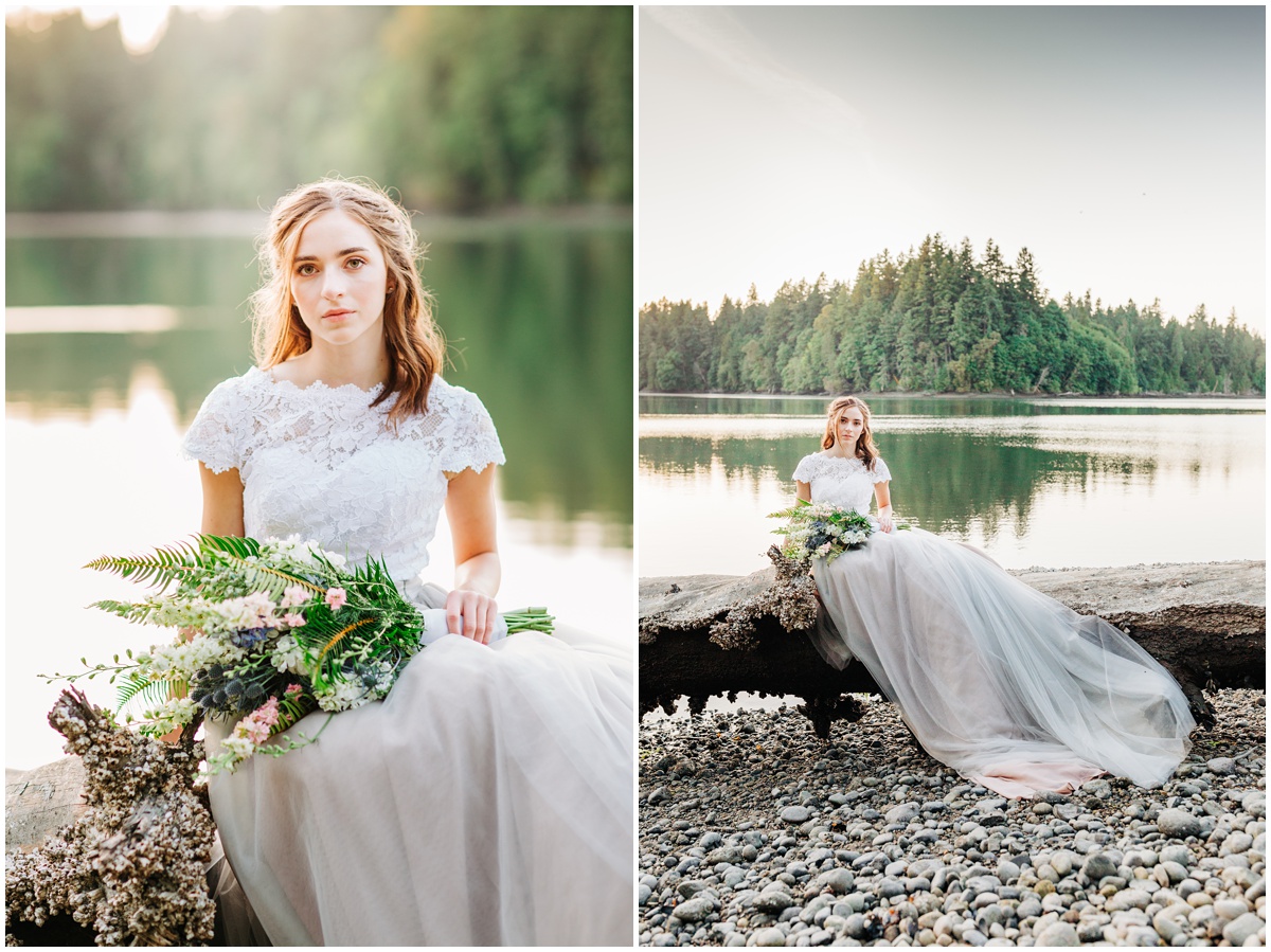 bride sits on log with rocky beach