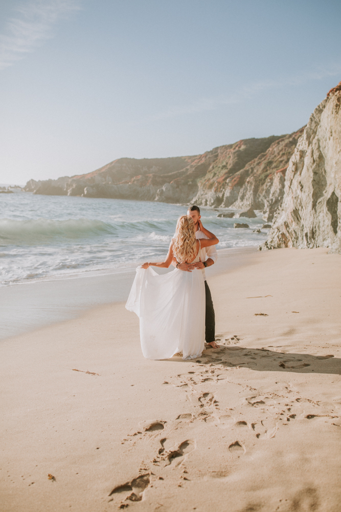 couple dancing on beach with sand