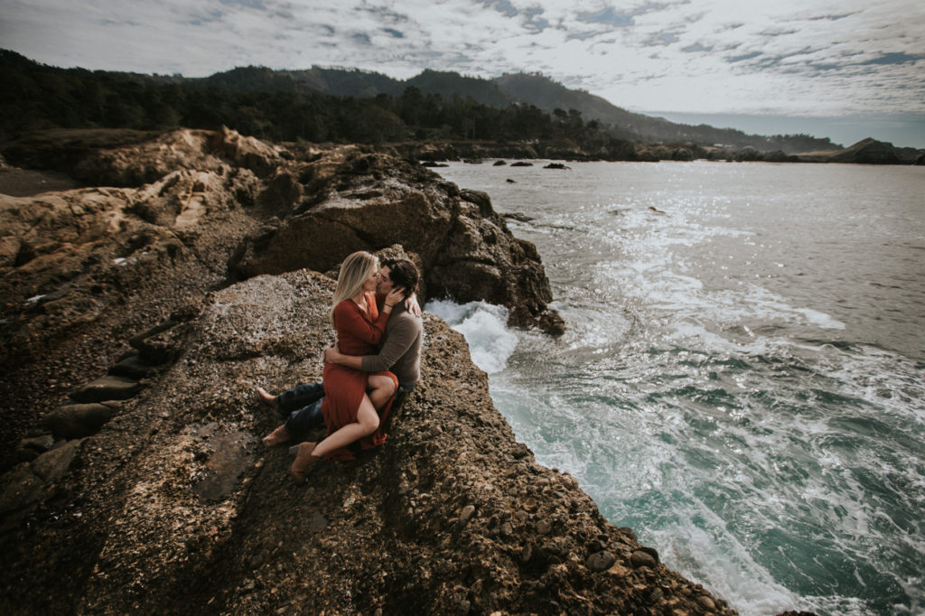 couple kissing on a rock