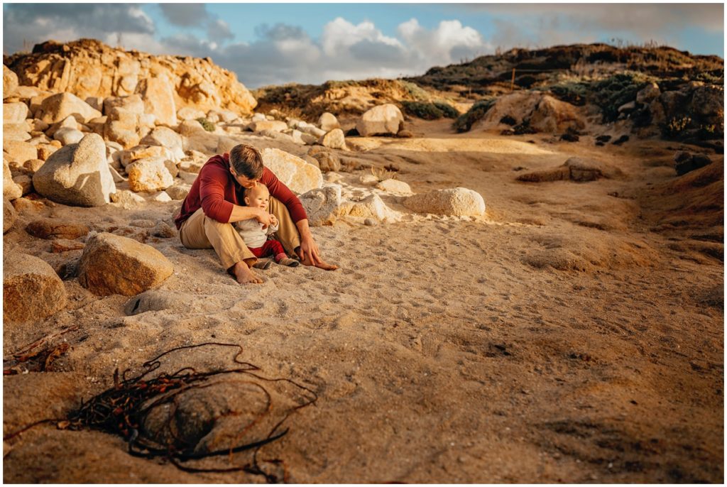 dad sitting with son on the beach