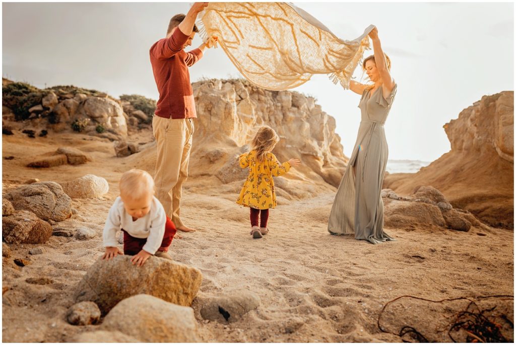 family playing blanket game at asilomar beach