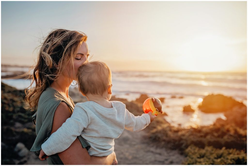 mother holding son at asilomar beach sunset