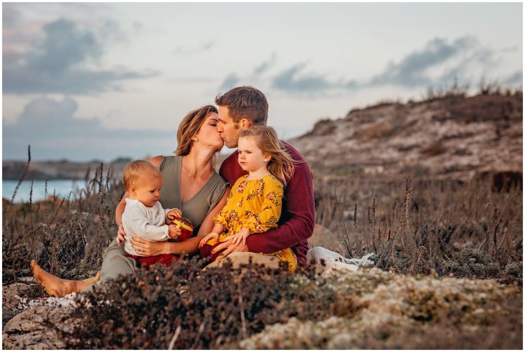 mom and dad kiss at sunset