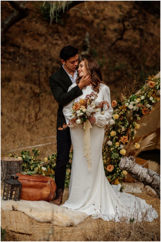 bride and groom standing by glamping tent