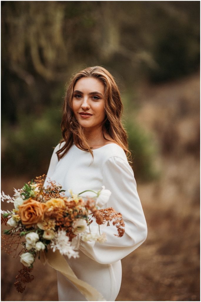 bride standing in wedding dress holding bouquet
