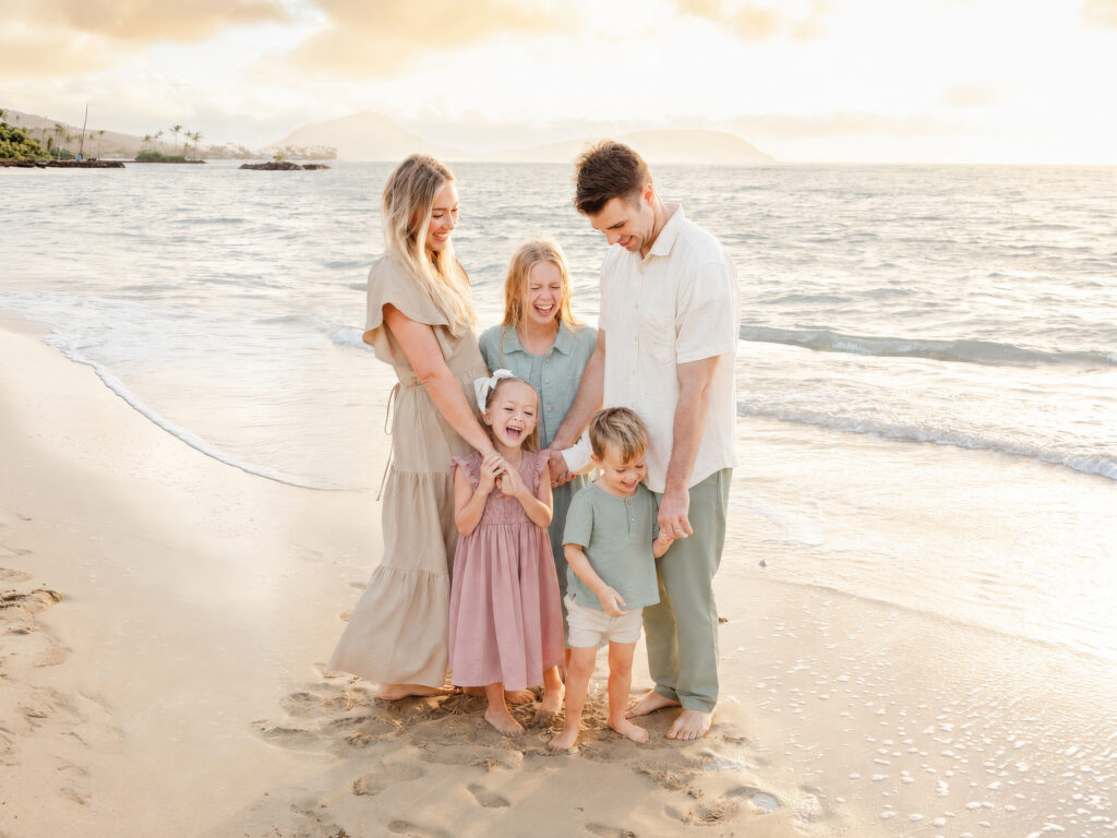 family wearing soft pastel color palate, dusty rose, muted aqua, sage, cream, and tan